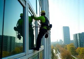 SchoonmaakMeesters technician washing tall urban windows Amsterdam